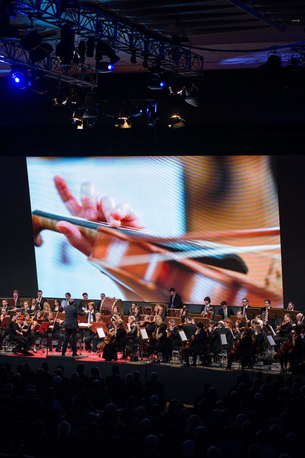 Orchester spielt vor Leinwand